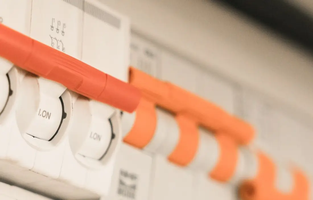 Close-up of the breaker switches on a white fuse board.